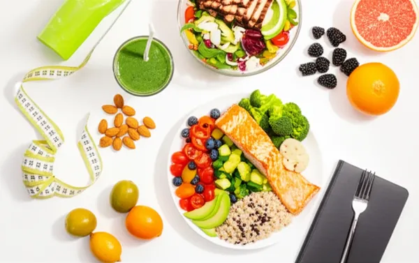 Healthy meal plan with protein shake, salmon, vegetables and fruits
